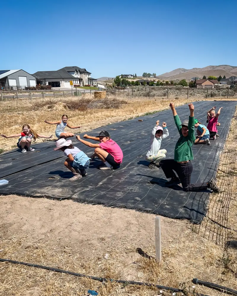 Campers cheering with arms up along the garden rows
