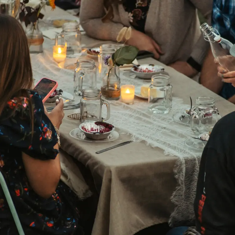 Candles glowing among mason jars and dessert bowls on the linen tablecloth