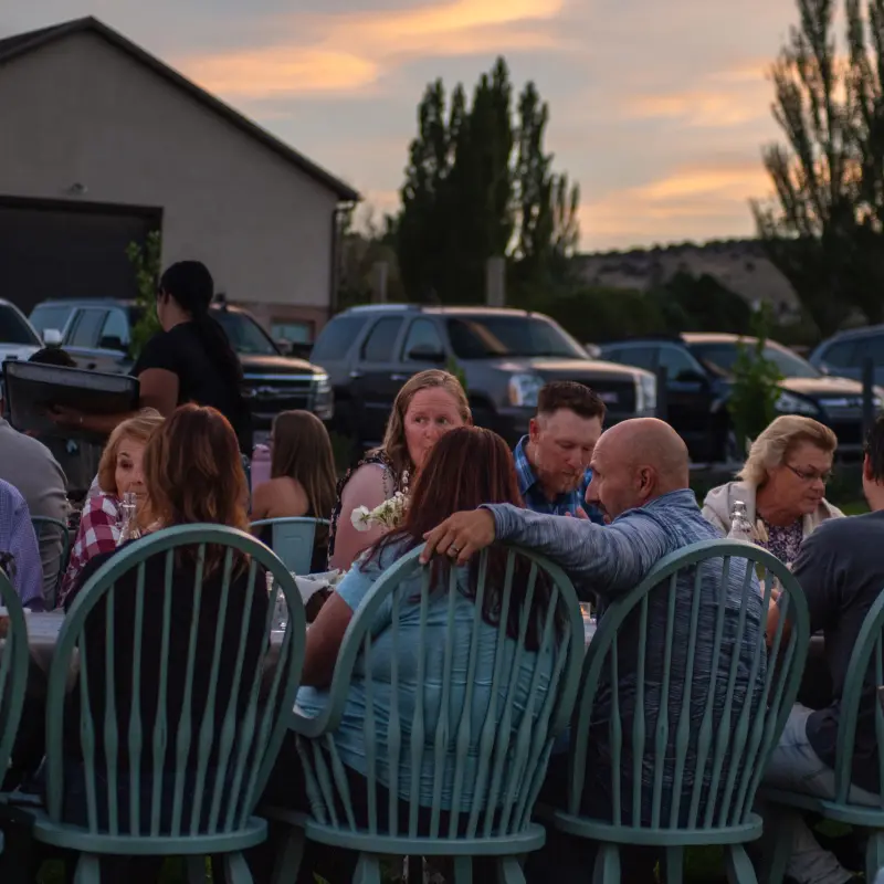 Guests at the long table as the sky turns gold at dusk