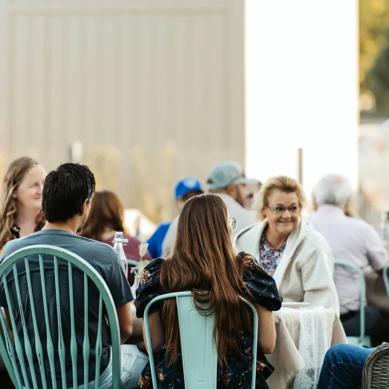 Guests in conversation around the table in the evening light