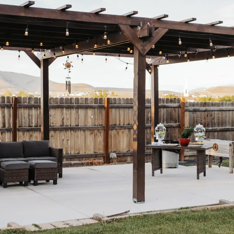 The farm pergola strung with lights, with a serving table and the mountains beyond