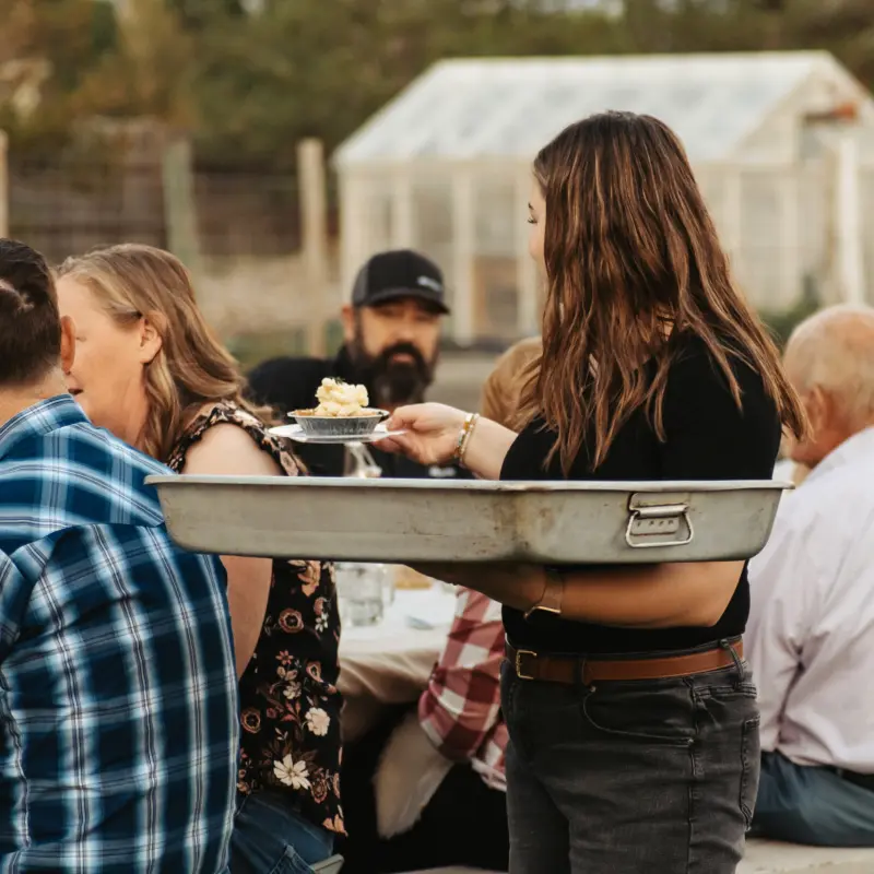 Dessert being served to guests at the table from a steel tray